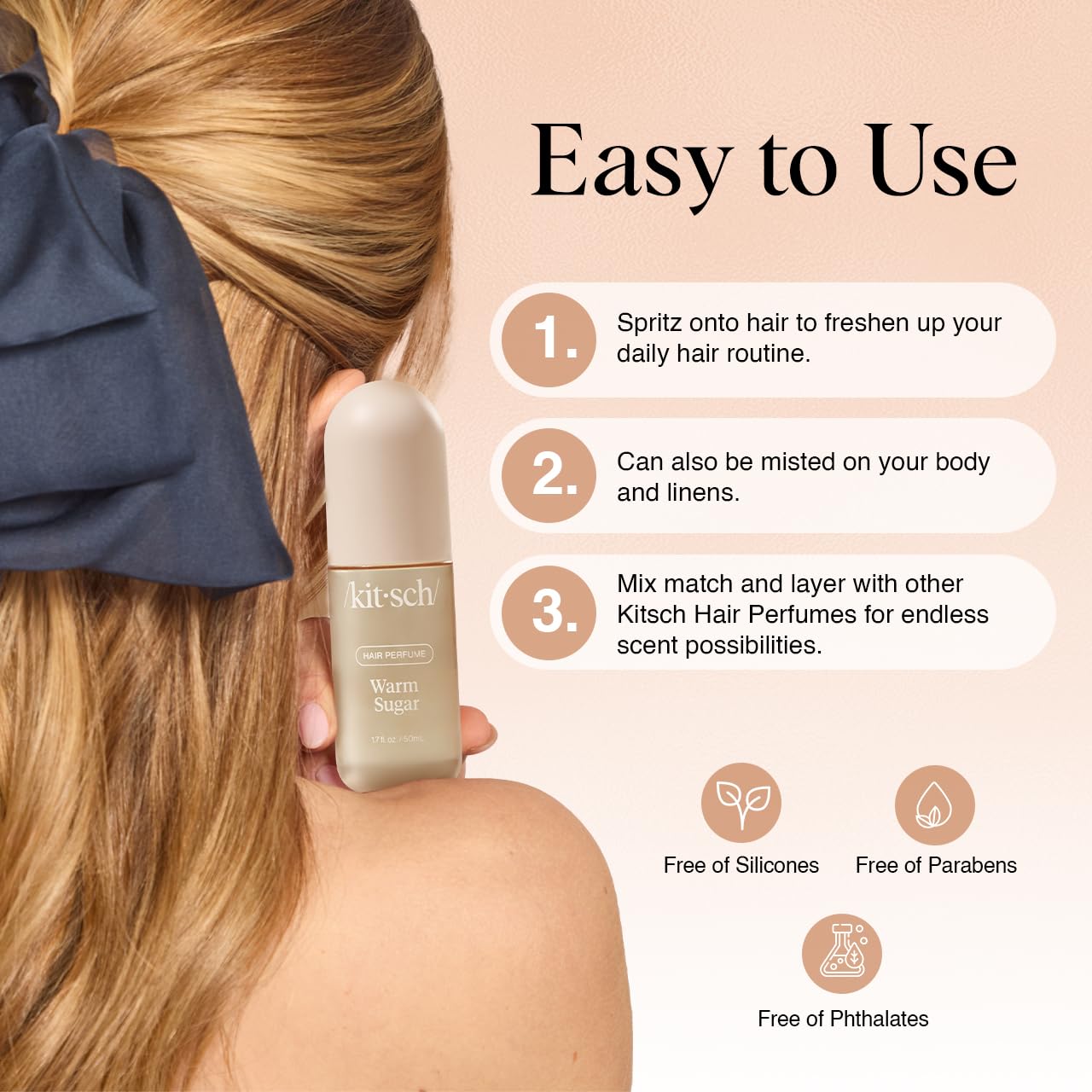Woman holding a bottle of Kitsch hair perfume with usage instructions on a beige background